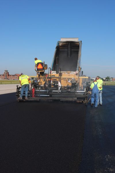 asphalt contractors laying asphalt paving using a asphalt paver