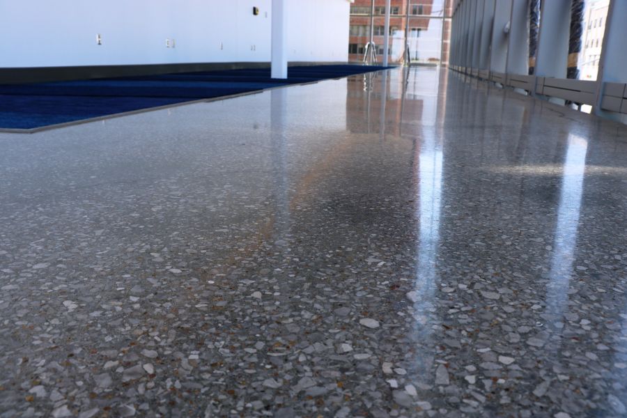Up close image of the decorative concrete flooring next to the bright blue carpeting