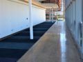 a hallway inside the KU Health Building featuring decorative concrete flooring and royal blue carpet