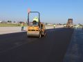 asphalt contractor driving an asphalt roller to help smooth out the asphalt paving