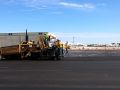a asphalt paver and asphalt contractors laying asphalt at the New Century Airport
