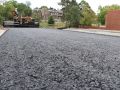 asphalt contractors laying asphalt paving through a big machine