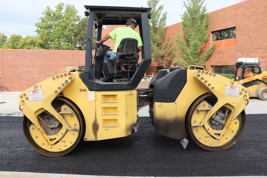 asphalt contractor inside an asphalt roller so he can smooth out the asphalt