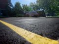 freshly paved and smoothed asphalt parking lot with new parking lines